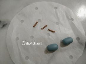 蓝面团排气后，搓成长条形，当帽子。可可粉搓细杀，切成跟帽子一样的长度。