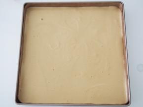 烤盘中铺上高温油布，将面糊倒入铺平，将烤盘在桌上磕几下震出气泡。