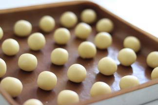 取出面团后，分割成大约10克一个的小面团，用手滚圆成小圆球。放置的时候稍微流出间隙。下一步需要摁压，会增大表面积。可以开始170度预热烤箱。