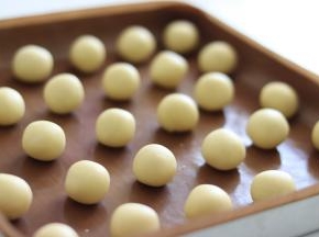 取出面团后，分割成大约10克一个的小面团，用手滚圆成小圆球。放置的时候稍微流出间隙。下一步需要摁压，会增大表面积。可以开始170度预热烤箱。