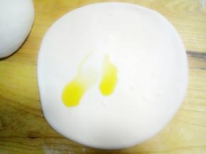 醒好的面团，分成两份，先取一份擀开成手指厚度，给面的正反面全部抹上油