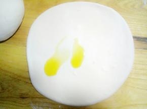 醒好的面团，分成两份，先取一份擀开成手指厚度，给面的正反面全部抹上油