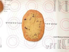10、取一份擀成牛舌状，用抹刀抹上一层蔓越梅绿豆沙。