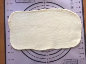 将其中一个面团擀成长方形，从下往上卷起，两边收口放入学厨300克吐司模具中，其余的面团也依次这样做