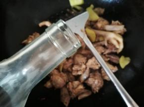 鸡炒香后，严锅边趁热倒入适量料酒，要听到兹啦一声，翻炒均匀