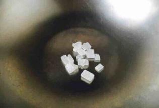 开始炒糖色 ，锅热了以后改用中火，把冰糖放入锅中。 一般炒色用油炒或者用水来炒，我们既不用油也不用水，我们是直接炒，这就是无油炒糖色法。