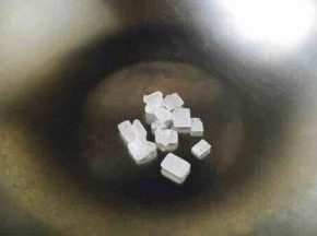 开始炒糖色 ，锅热了以后改用中火，把冰糖放入锅中。 一般炒色用油炒或者用水来炒，我们既不用油也不用水，我们是直接炒，这就是无油炒糖色法。