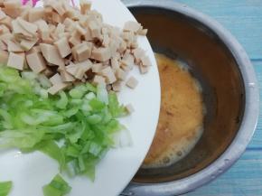 然后把火腿肠和葱加入鸡蛋中，搅打均匀