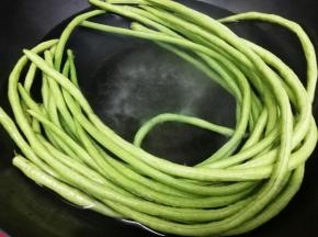 长豆角洗干净去掉两头，然后放入锅中炒熟