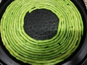 电饼铛中刷一层油，不要开火，然后把焯熟的豆角放入电饼铛中