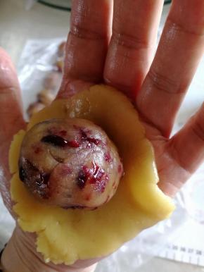 粉皮用手掌按扁，将馅料放入，利用虎口的位置包好。