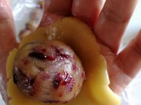 粉皮用手掌按扁，将馅料放入，利用虎口的位置包好。