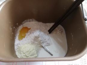 除黄油，盐，耐高糖酵母的原材料放入面包机，用筷子稍微搅拌均匀。