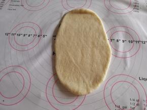 用擀面杖擀卷成长条形。