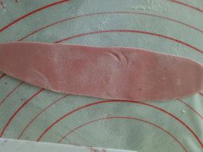 剩下的红色面团再加入一点红曲粉，揉成颜色深一点的红色面团，擀成长一点的面片