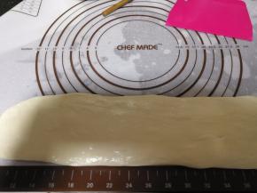 硅胶垫上面涂抹一点花生油，然后将面团整理成0.5cm的厚度，5cm左右的宽度，手上也要涂抹一点花生油再操作。锅里倒入适量的花生油烧热。