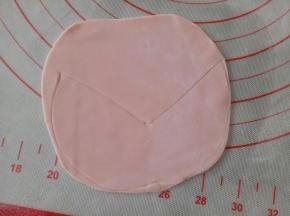 剩下的红色面团继续揉一下，擀成薄片，画出如图中的样子，做为比基尼上衣
