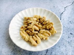 核桃去壳，核桃仁洗干净，将核桃仁放在微波炉里分次加热烤熟。加热时间要根据核桃仁的大小和微波炉的功率而定，加热时要勤翻动核桃仁。也可以用平底锅焙熟。