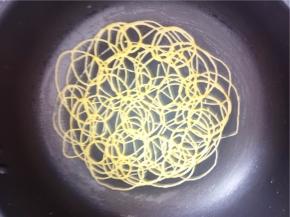 不粘锅开小火无需刷油，挤入面糊。画圈圈