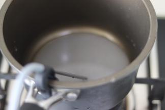 放到燃气上，温度计插放到锅边，伸入糖水中。