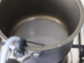 放到燃气上，温度计插放到锅边，伸入糖水中。