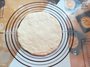 披萨面团发酵好后，取出轻压排气，在揉面垫上撑成8寸大小，也可以用擀面杖擀成8寸的