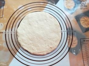 披萨面团发酵好后，取出轻压排气，在揉面垫上撑成8寸大小，也可以用擀面杖擀成8寸的