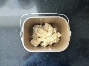 6、面包机里放入干酵母，然后把面团剪成小块也放入盆中。