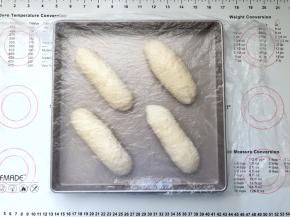 14、收口朝下码入烤盘中，盖上保鲜膜室温下进行发酵。