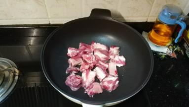 不粘锅放入少许油，将排骨平铺好煎至金黄