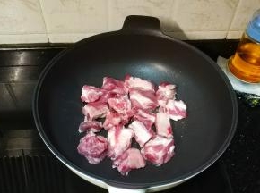 不粘锅放入少许油，将排骨平铺好煎至金黄