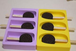 冰棒模具插上冰棍，然后将奥利奥饼干插入到冰棍中