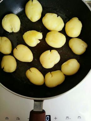 平底锅热油 烧热后放入小土豆煎 煎的时候撒少许盐