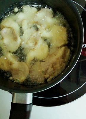 锅里倒入适量的油  烧至六成热放蘑菇 小火炸