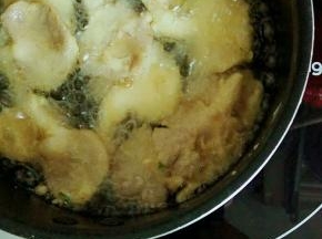 锅里倒入适量的油  烧至六成热放蘑菇 小火炸
