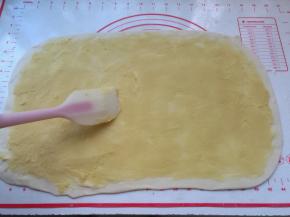 3、	松弛好的油皮面团取出来不用揉，放在案板上，轻轻按扁，用擀面杖韩城长方形大面片，铺上油酥，用刮刀或刮板整理平整，让油酥均匀地平铺在油皮面上，这一步要耐心点哈。