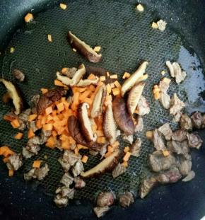 牛肉变色后 加入胡萝卜和香菇翻炒