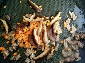 牛肉变色后 加入胡萝卜和香菇翻炒