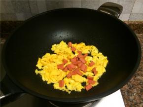 放入火腿肠翻炒10秒。