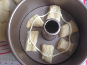 将小面团放入8寸活底不粘中空模具里，你也可以用其他模具代替。每块小面团之间要留有空间，不用铺满，挤上一圈沙拉酱