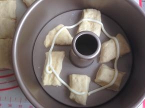 将小面团放入8寸活底不粘中空模具里，你也可以用其他模具代替。每块小面团之间要留有空间，不用铺满，挤上一圈沙拉酱