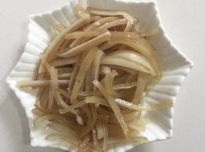 猪皮煮熟，用镊子拔去猪皮上的绒毛，切成条备用。