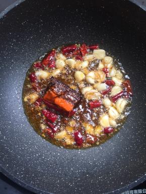 锅烧热倒入适量的油，放入花椒，蒜瓣，干辣椒，火锅底料炒出红油。