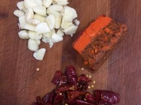 蒜瓣剥皮拍碎，干辣椒切成段儿，一块儿火锅底料备用。