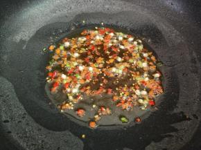 蒸蛏子的时候可以同时起锅，把锅里面倒入少许的油，下花椒小火煸出香味以后，再把花椒籽捞出来不用，再加入葱白和小米椒煸出香味
