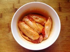 将鸡翅放入碗里，加入腌料，用手抓匀，按摩几分钟，让腌料充分与鸡翅融合，盖上保鲜膜放入冰箱冷藏腌制一夜。