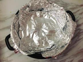 将腌制好的鸡翅取出，砂锅底部放烤架，烤架上铺上两、三层锡箔纸。