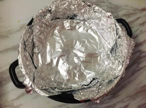 将腌制好的鸡翅取出，砂锅底部放烤架，烤架上铺上两、三层锡箔纸。