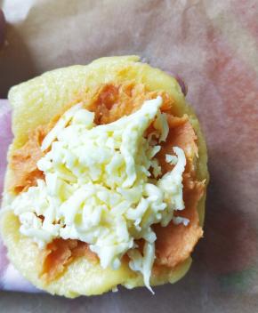 取一个面团压扁。放入适量红薯泥，再放入适量芝士。