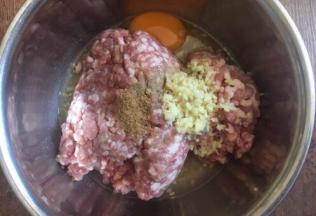 肉馅里放入一个鸡蛋，放入3分之一小勺的十三香，放入3分之一小勺的白胡椒粉，放入2勺的料酒（白糯米酒），放入15g的姜末，朝一个方向搅拌均匀。